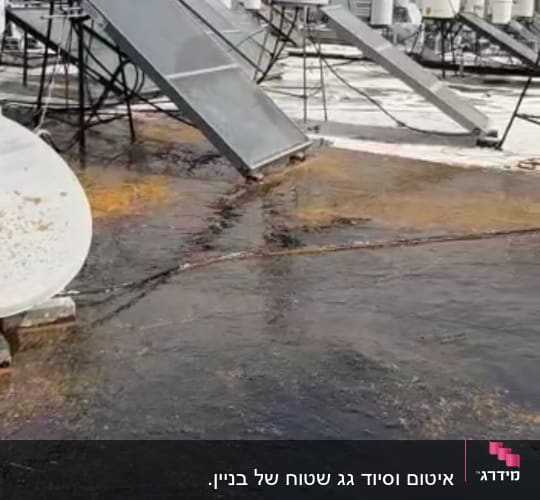 גג עם קולטי שמש ואיטום זפת שחור
